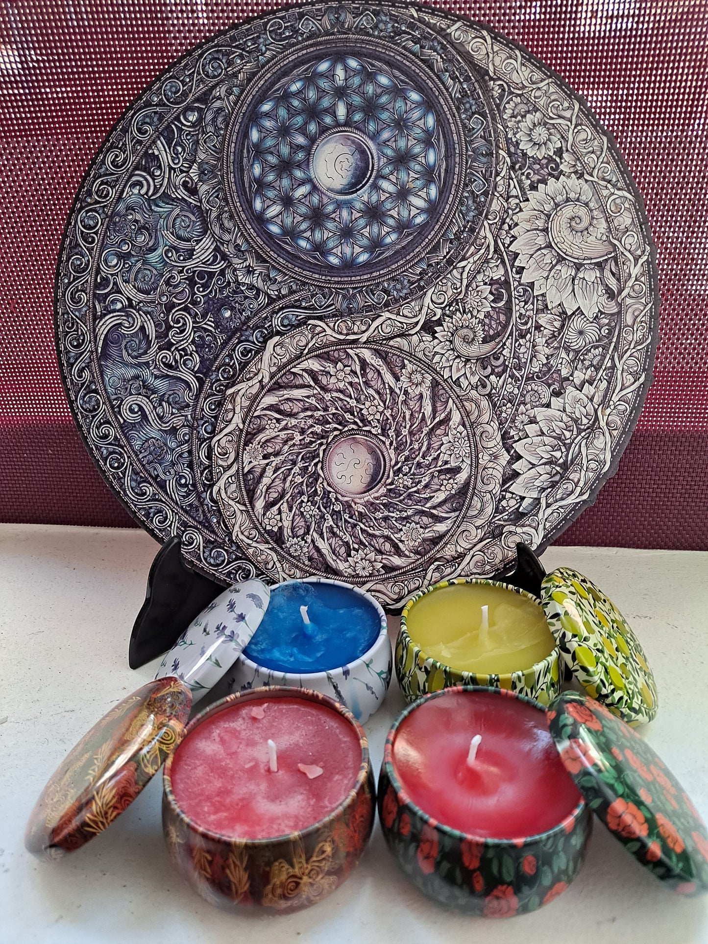 Velas aromáticas de soja en envase metálico con tapa, y un puzzle con forma de Yin Yang al fondo