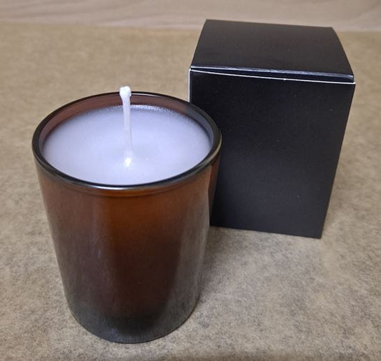Vela de cera de abeja en vaso de vidrio ámbar