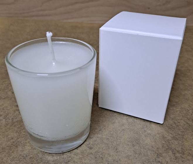 Vela de cera de abeja en vaso de vidrio transparente